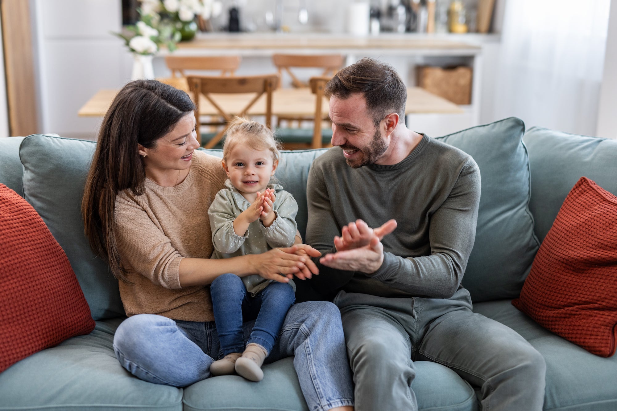 Family of three sitting on a couch in a living room