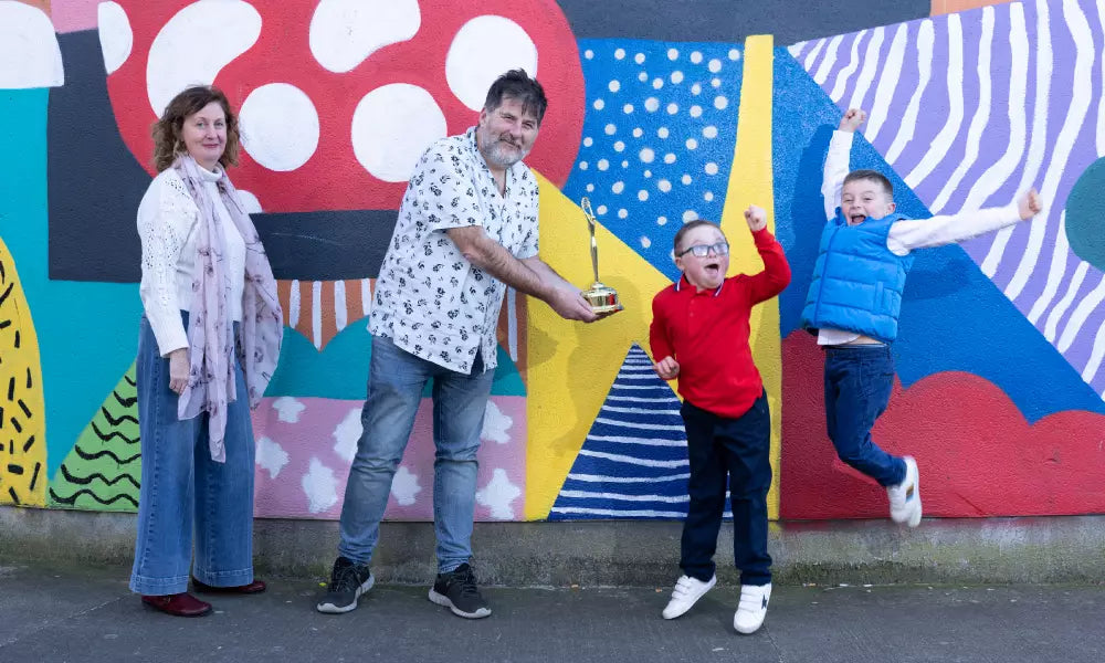 Family of four in front of a colorful mural