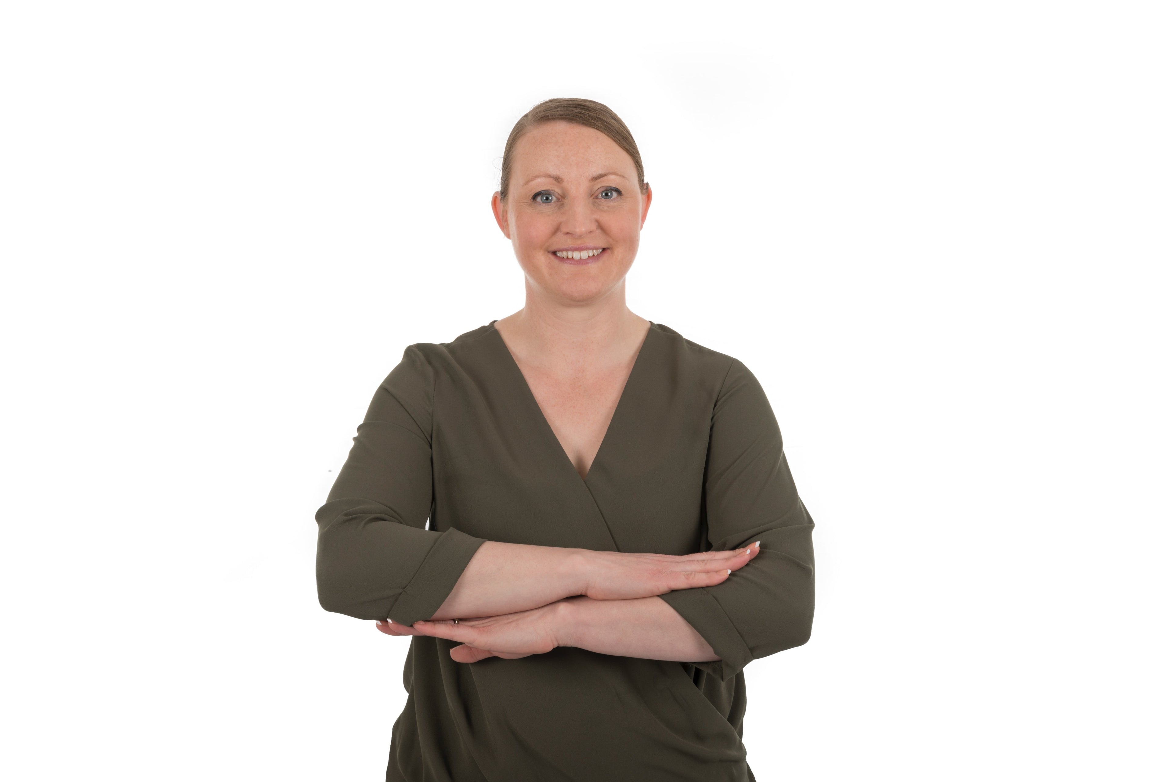 Woman wearing a green dress with arms crossed on a white background